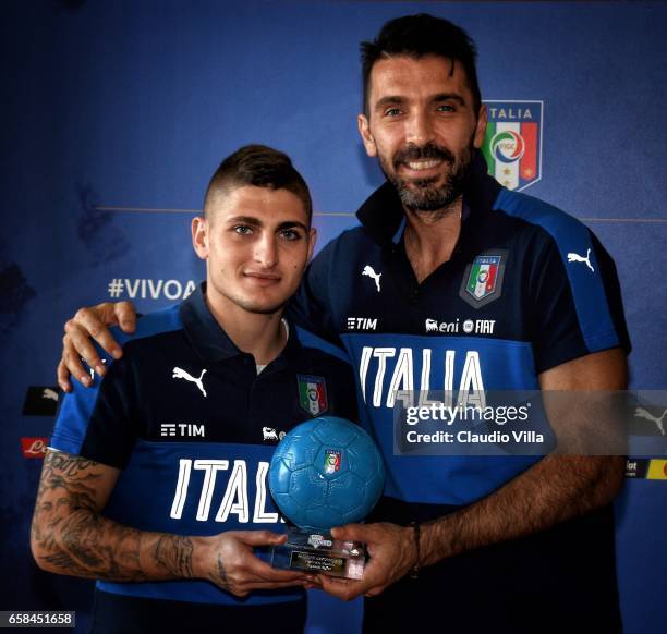 Gianluigi Buffon receives the Pallone Azzurro trophy from Marco Verratti at Coverciano on March 26, 2017 in Florence, Italy.