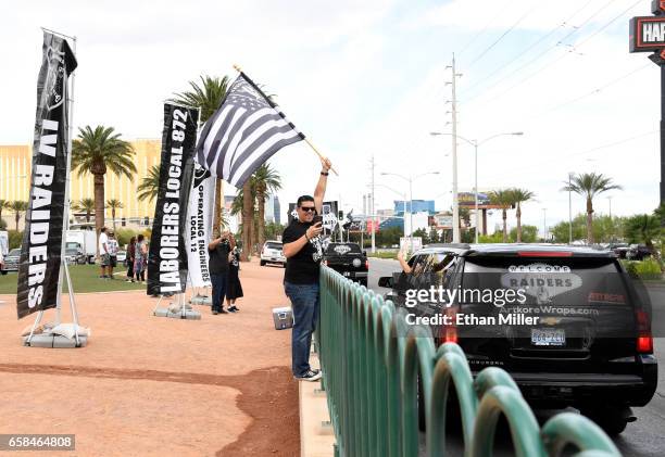 Oakland Raiders fan Matt Gutierrez of Nevada waves a Raiders flag on the Las Vegas Strip near the Welcome to Fabulous Las Vegas sign after National...