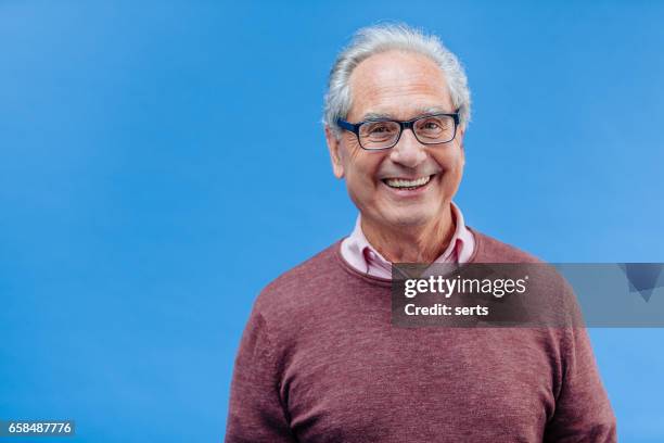 porträtt av leende senior business man - blue background portrait bildbanksfoton och bilder