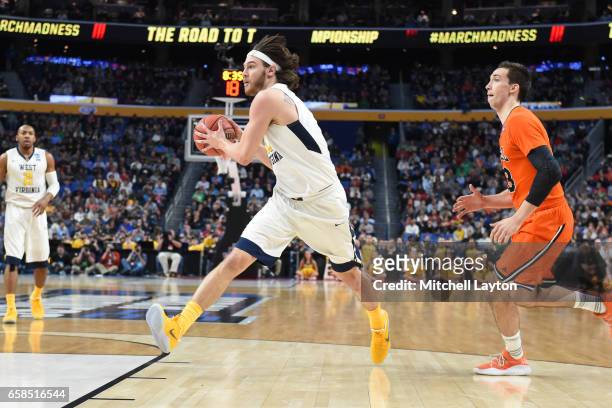 Nathan Adrian of the West Virginia Mountaineers drives to the basket during the First Round of the NCAA Basketball Tournament against the Bucknell...