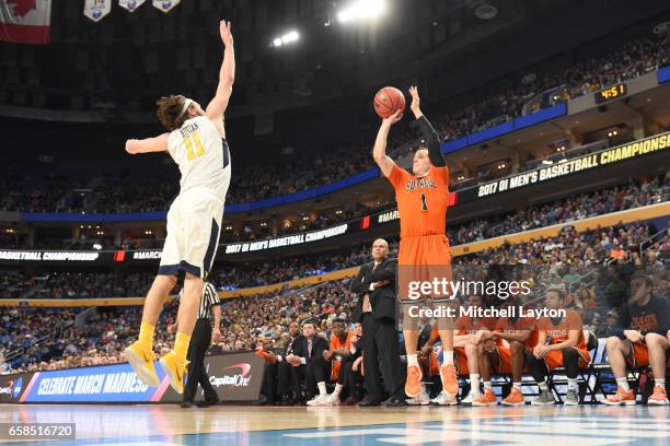 Kimbal Mackenzie of the Bucknell Bison takes a jump shot over Nathan Adrian of the West Virginia Mountaineers during the First Round of the NCAA...