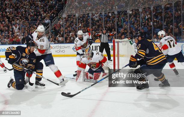 Zach Bogosian of the Buffalo Sabres controls the puck in front of teammate Zemgus Girgensons and Jakub Kindl of the Florida Panthers prior to scoring...