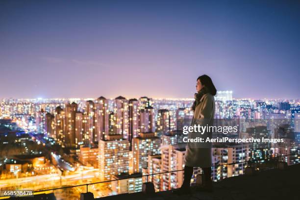 side view of woman standing in front of city - electrical overload stockfoto's en -beelden