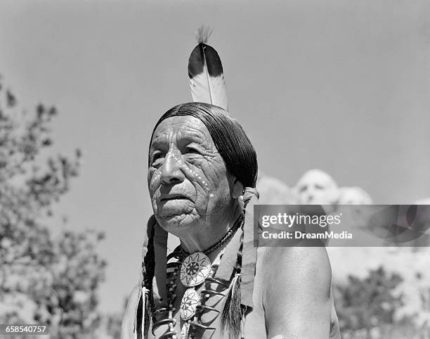 1950s 1960s NATIVE AMERICAN MAN SIOUX WITH MOUNT RUSHMORE SOUTH DAKOTA IN BACKGROUND