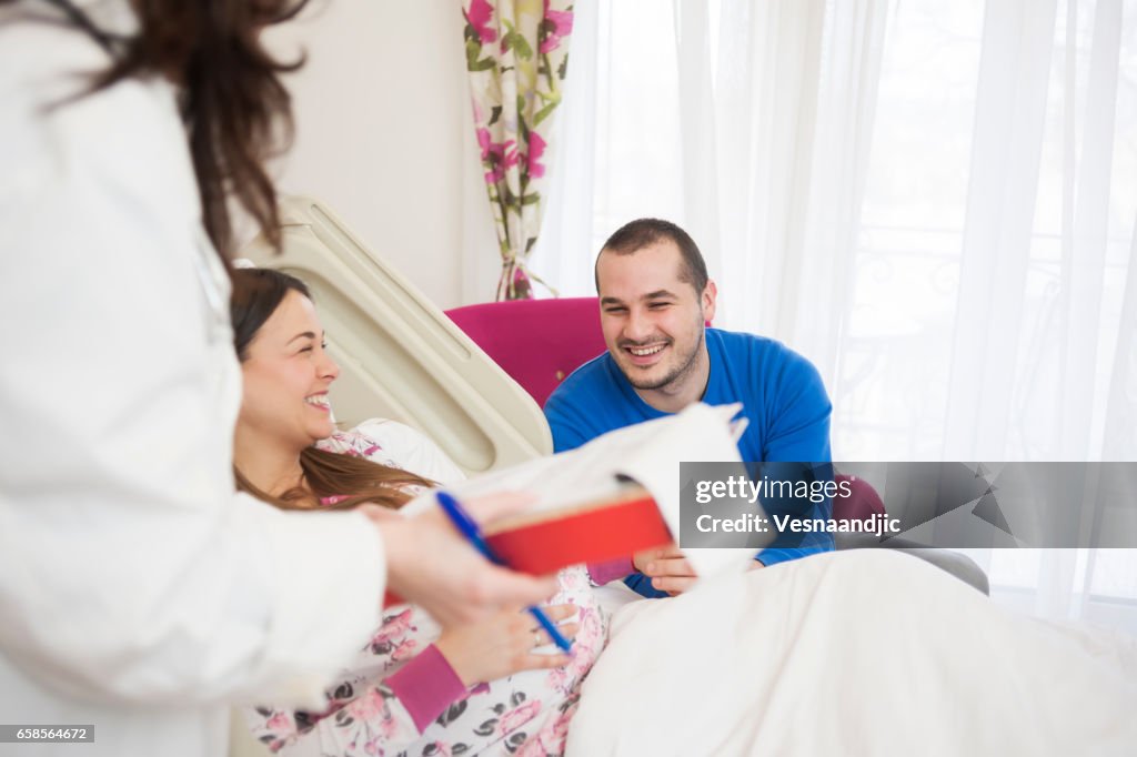 Doctor Talking To Pregnant Woman And Her Husband