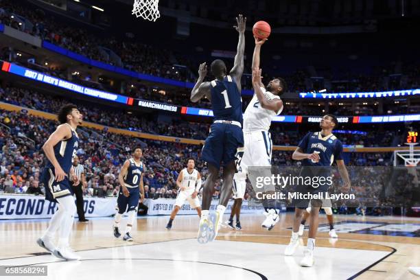 Kris Jenkins of the Villanova Wildcats takes a shot over Mawdo Sallah of the Mount St. Mary's Mountaineers the First Round of the NCAA Basketball...