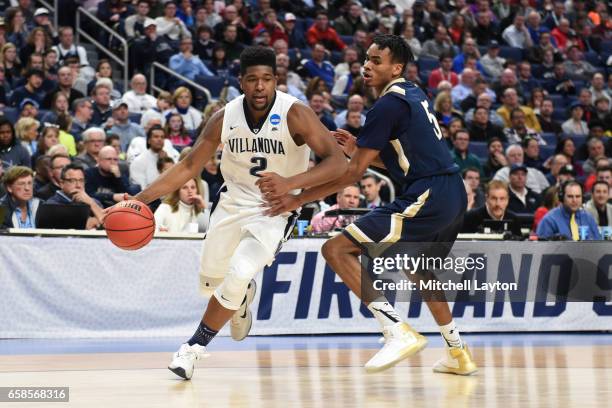 Kris Jenkins of the Villanova Wildcats dribbles around Chris Wray of the Mount St. Mary's Mountaineers during the First Round of the NCAA Basketball...