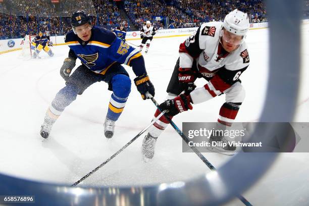 Colton Parayko of the St. Louis Blues and Lawson Crouse of the Arizona Coyotes chase down the puck at the Scottrade Center on March 27, 2017 in St....