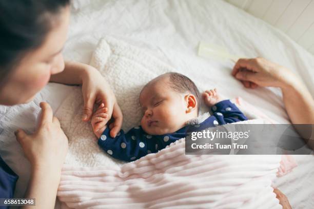 mother holding baby girl hand - mother sleeping baby bildbanksfoton och bilder