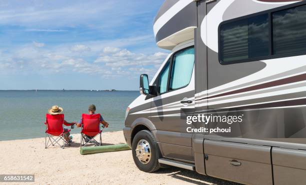 road trip in usa, couple relaxing near water - rv beach stock pictures, royalty-free photos & images