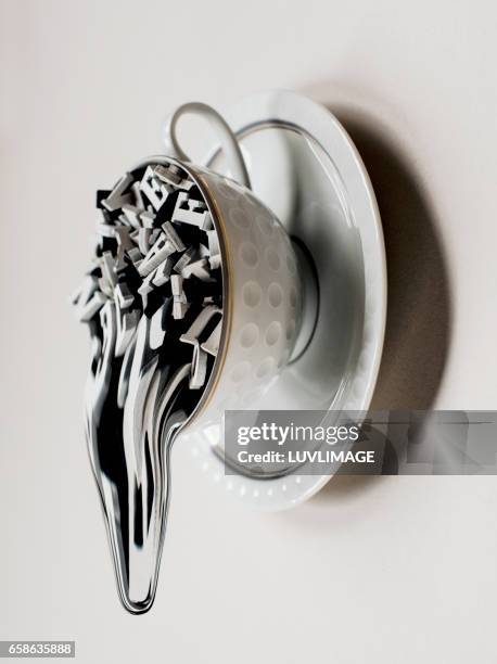 surreal teacup filled with letters which drip downwards. - offbeat documentation stock pictures, royalty-free photos & images