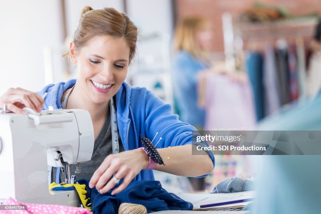 Självsäkra kvinnan använder en symaskin