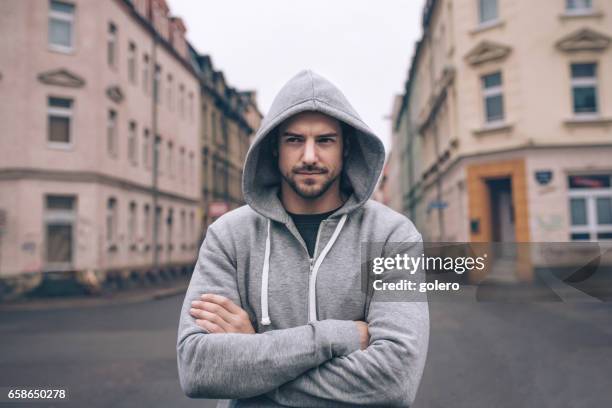 retrato de joven con capucha en calles de la ciudad - camisa con capucha fotografías e imágenes de stock