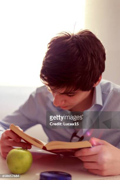 junger mann liest ein buch - getönt stockfoto's en -beelden