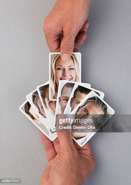 hand selecting playing card with face from pack - hand picking up stock pictures, royalty-free photos & images