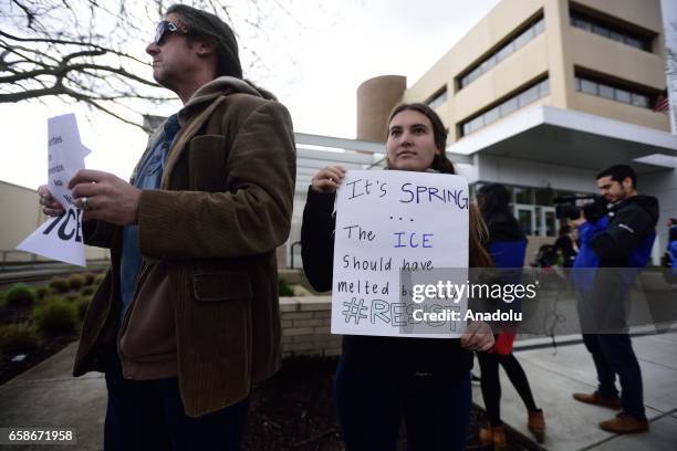 Woman holds a banner reading "It's spring - The ICE should have melted by now" during a protest outside the Immigration and Customs Enforcement...