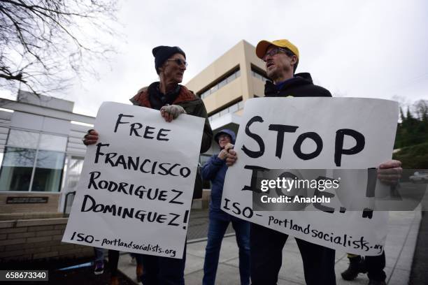 Two men hold banners reading "Free Francisco Rodriguez Dominguez - Stop I.C.E" during a protest outside the Immigration and Customs Enforcement...