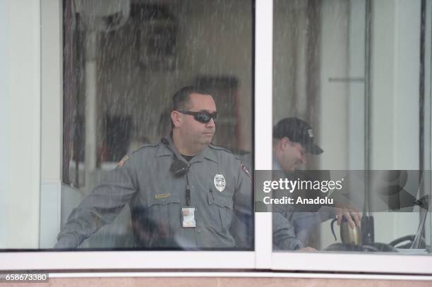 Security guard monitors the scene as protesters gather outside the Immigration and Customs Enforcement building in Portland, Oregon, United States,...