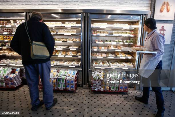 Customer looks at products as a chef re-stacks shelves with freshly made baguette sandwiches inside a branch of food retailer Pret a Manger Ltd. In...