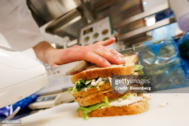 Chef slices a freshly made sandwich in the kitchen of a branch of food retailer Pret a Manger Ltd. In London, U.K., on Monday, March 27, 2017. Food...