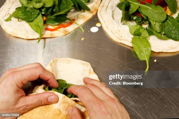 Chef prepares sandwich wraps in the kitchen of a branch of food retailer Pret a Manger Ltd. In London, U.K., on Monday, March 27, 2017. Food chain...