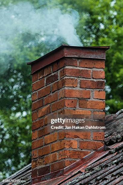 smoke from cabin chimney - chimney stock pictures, royalty-free photos & images