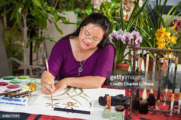 chinese brush painter creates orchid painting - goleta stock pictures, royalty-free photos & images