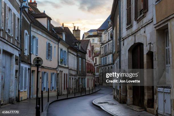 sunset over narrow street in french village - village france photos et images de collection