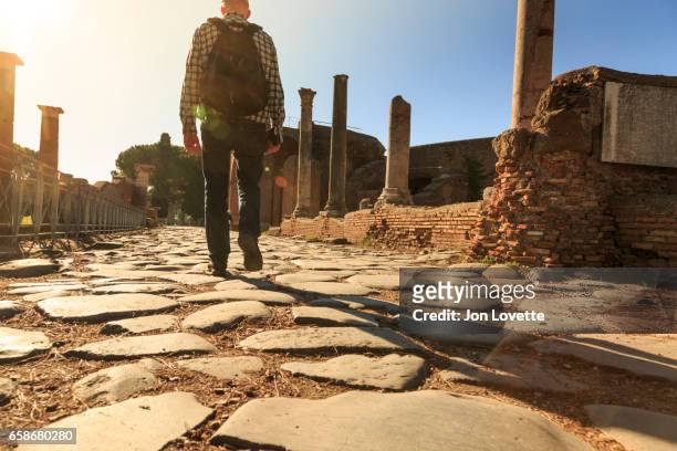 walking on ancient roman road in ostia antica - antica roma fotografías e imágenes de stock