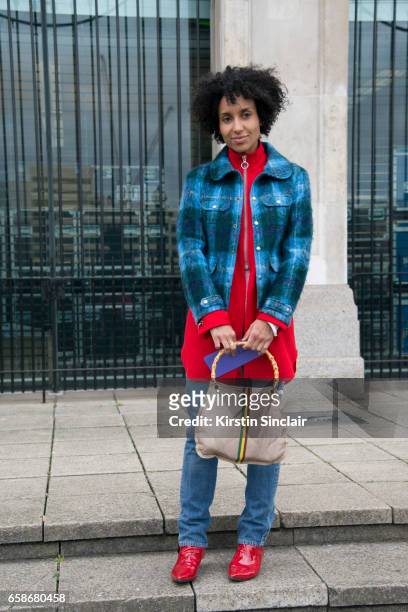Guest wears a checked jacket and red boots on day 3 of London Womens Fashion Week Autumn/Winter 2017, on February 19, 2017 in London, England.