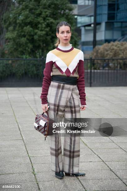 Fashion blogger Irina Lakicevic wears Celine trousers and boots, Mulberry bag and sweater on day 3 of London Womens Fashion Week Autumn/Winter 2017,...