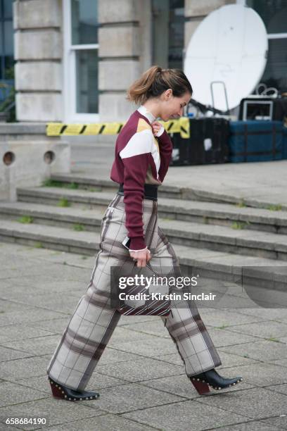 Fashion blogger Irina Lakicevic wears Celine trousers and boots, Mulberry bag and sweater on day 3 of London Womens Fashion Week Autumn/Winter 2017,...