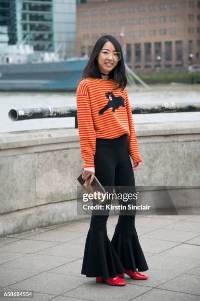 Fashion blogger YuYu Zhangzou wears a Gucci sweater, Away Lee trousers, Mulberry bag, Jinnn glasses and Dorateymur shoes on day 3 of London Womens...