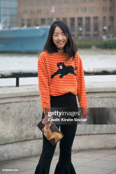 Fashion blogger YuYu Zhangzou wears a Gucci sweater, Away Lee trousers, Mulberry bag, Jinnn glasses on day 3 of London Womens Fashion Week...