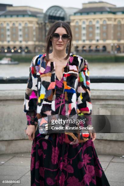 Fashion blogger Anisa Sojka wears a Jane and Tash jacket, Matthew Williamson dress and sunglasses and a Furla bag on day 3 of London Womens Fashion...