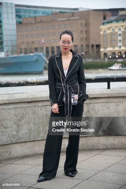 Fashion blogger Mariko Kuo wears a Karen Millen suit, Furla bag and Black Eyewear glasses on day 3 of London Womens Fashion Week Autumn/Winter 2017,...