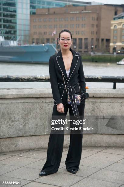 Fashion blogger Mariko Kuo wears a Karen Millen suit, Furla bag and Black Eyewear glasses on day 3 of London Womens Fashion Week Autumn/Winter 2017,...