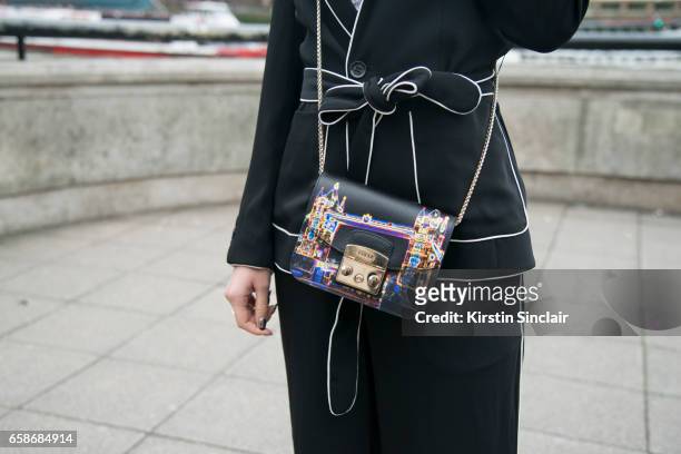 Fashion blogger Mariko Kuo wears a Karen Millen suit, Furla bag on day 3 of London Womens Fashion Week Autumn/Winter 2017, on February 19, 2017 in...