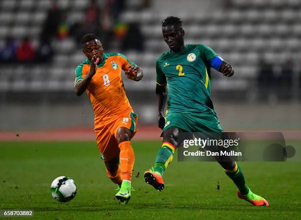 Kara Mbodj of Senegal holds off Cyriac Gohi Bi of the Ivory Coast during the International Friendly match between the Ivory Coast and Senegal at the...