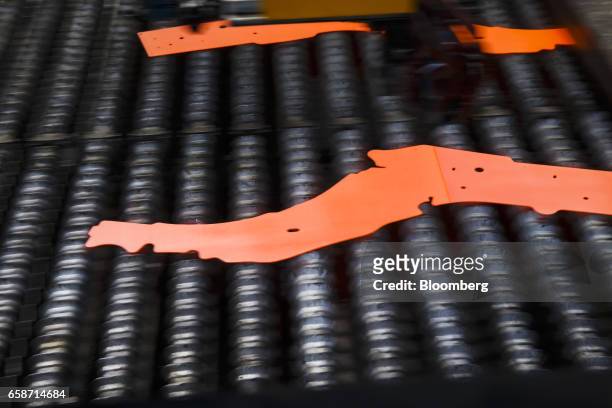 Shaped hot steel sheets pass along an automated production line at the auto parts manufacturing plant operated by Gestamp Automocion SA plant in...