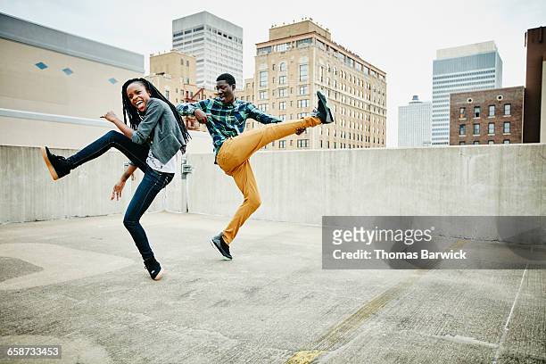 couple dancing together on rooftop of building - zwarte spijkerbroek stockfoto's en -beelden