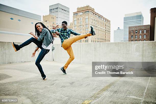 couple dancing together on rooftop of building - building partnership stock pictures, royalty-free photos & images