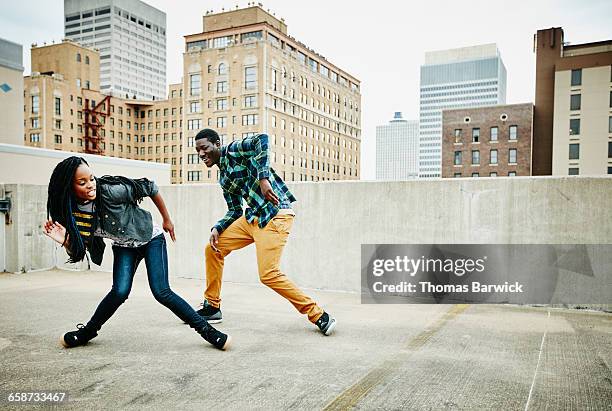 smiling couple dancing together on rooftop - black culture stock pictures, royalty-free photos & images