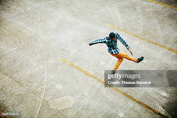 overhead view of man dancing in empty parking lot - lot of people fotografías e imágenes de stock