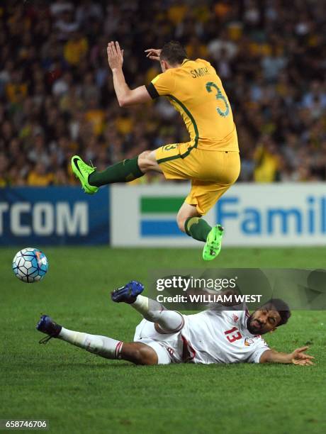 Australia's Brad Smith leaps over the diving tackle of United Arab Emirates player Khamis Esmaeel in their World Cup qualifying football match in...