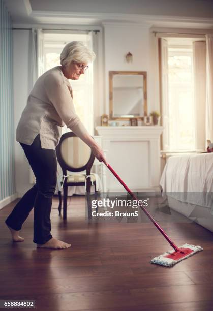longitud total de una mujer senior de limpiar el piso. - aljofifa fotografías e imágenes de stock