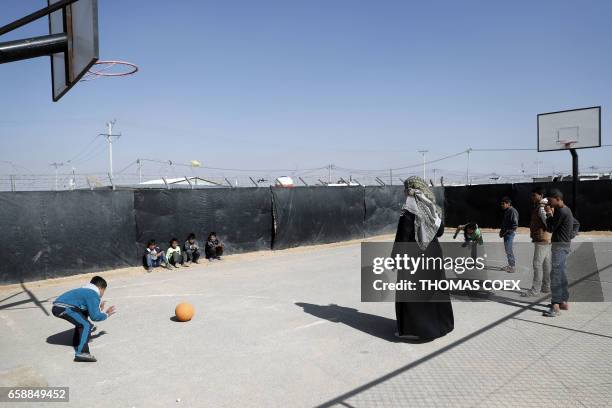 Syrian refugees play with a ball at the Zaatari camp which shelters some 80,000 Syrian refugees on the Jordanian border with war-ravaged Syria on...