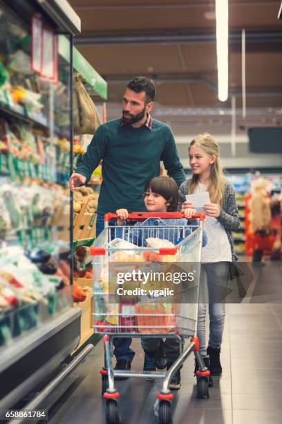 vater mit sohn und tochter in a supermarkt. - shopping cart stock-fotos und bilder