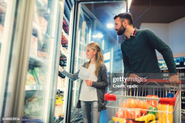 father and daughter in a supermarket. - supermarket fridge stock pictures, royalty-free photos & images
