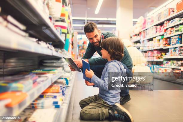 vater und sohn in einem supermarkt. - office supply stock-fotos und bilder